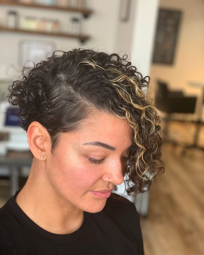 curly pixie cut with long highlighted bangs