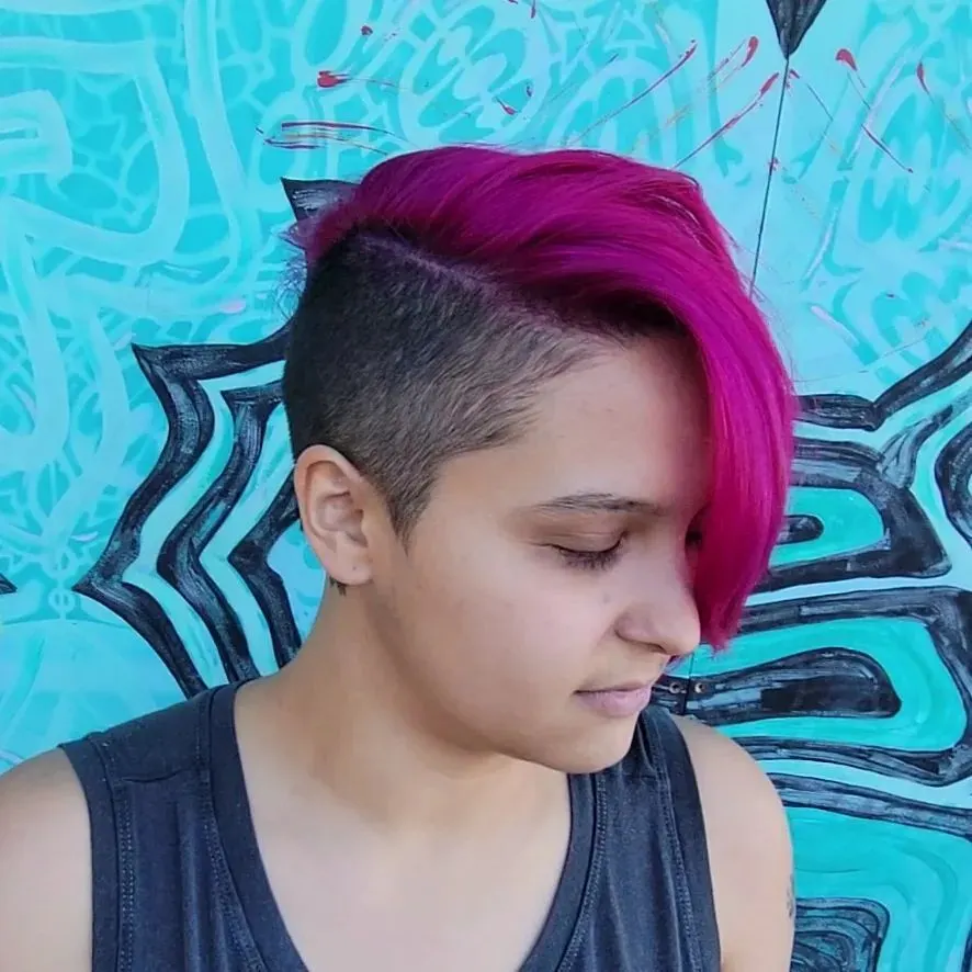 asymmetrical pixie cut with pink bangs and shaved side