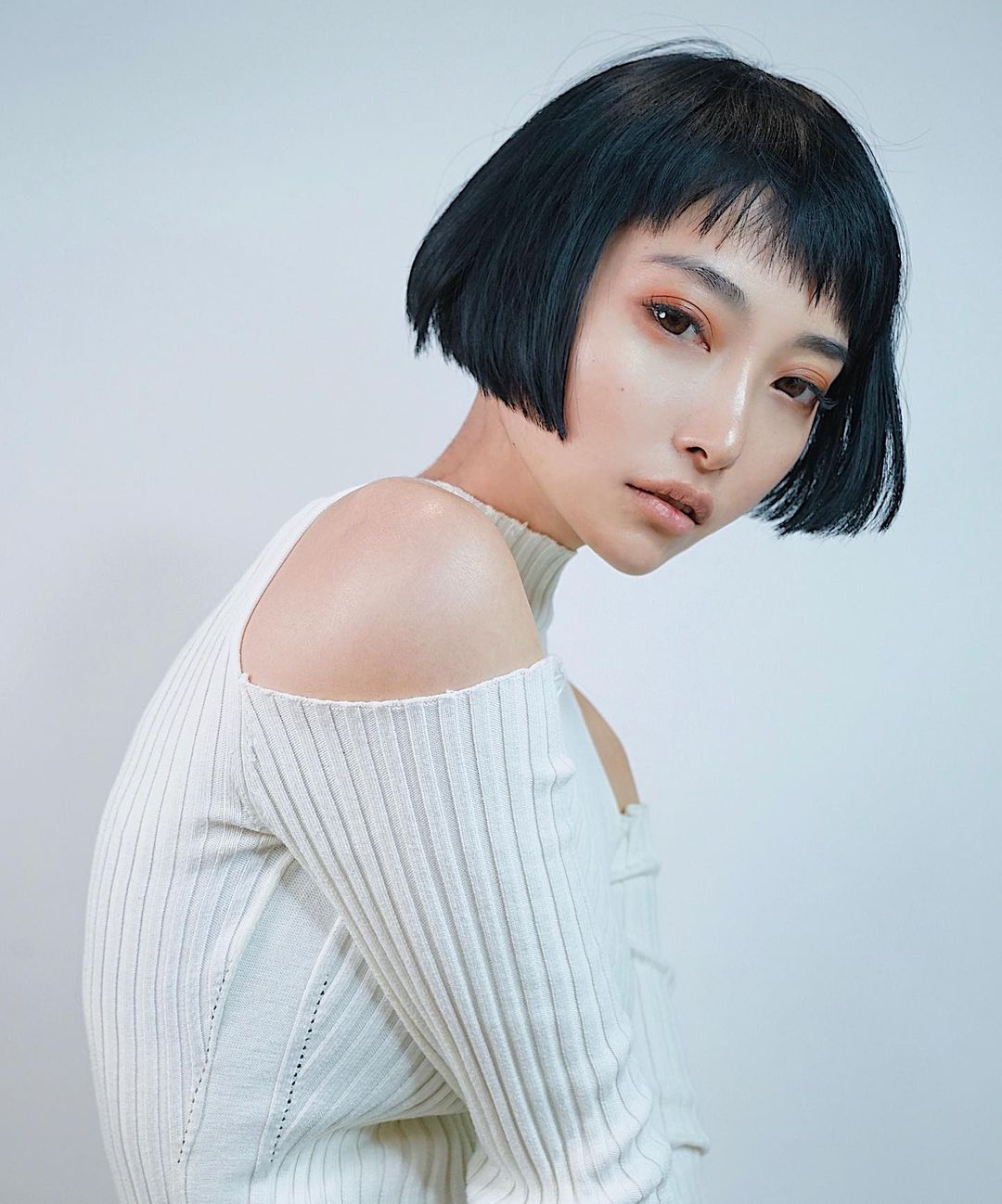 heart-shaped face and a blunt bob with textured fringe