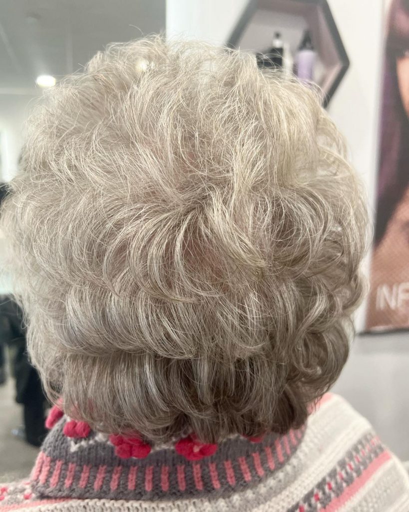 corte de cabelo curto encaracolado em camadas para mulheres com mais de 60 anos