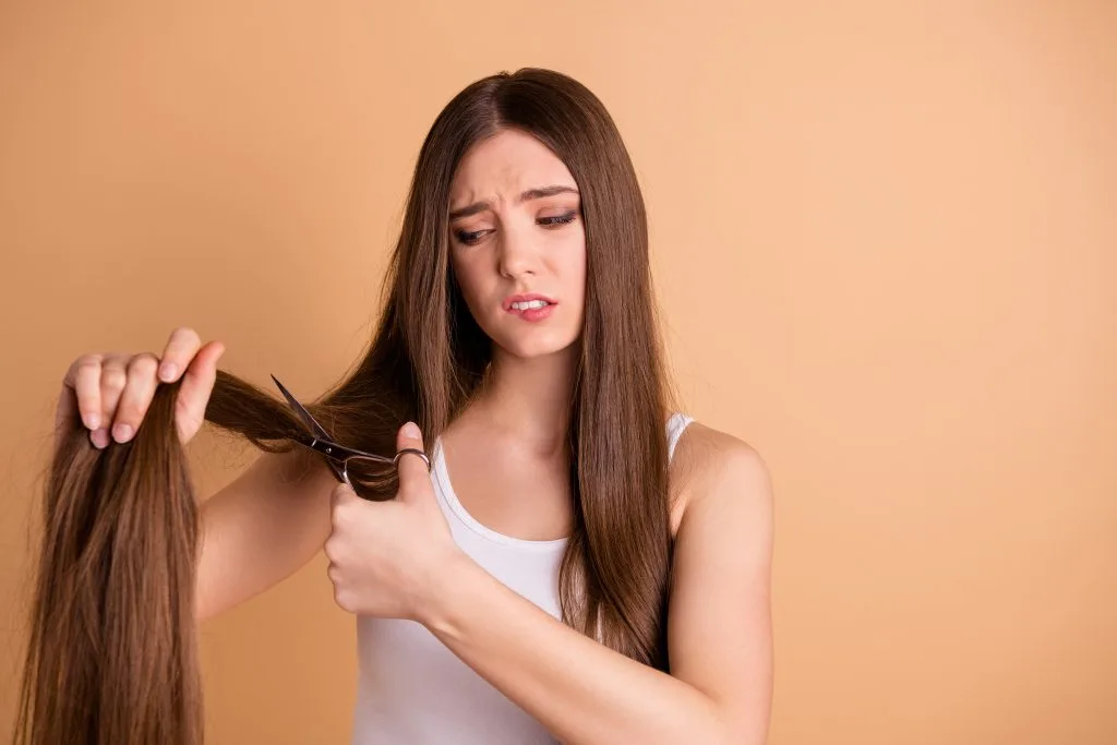 disappointed woman cutting her long hair