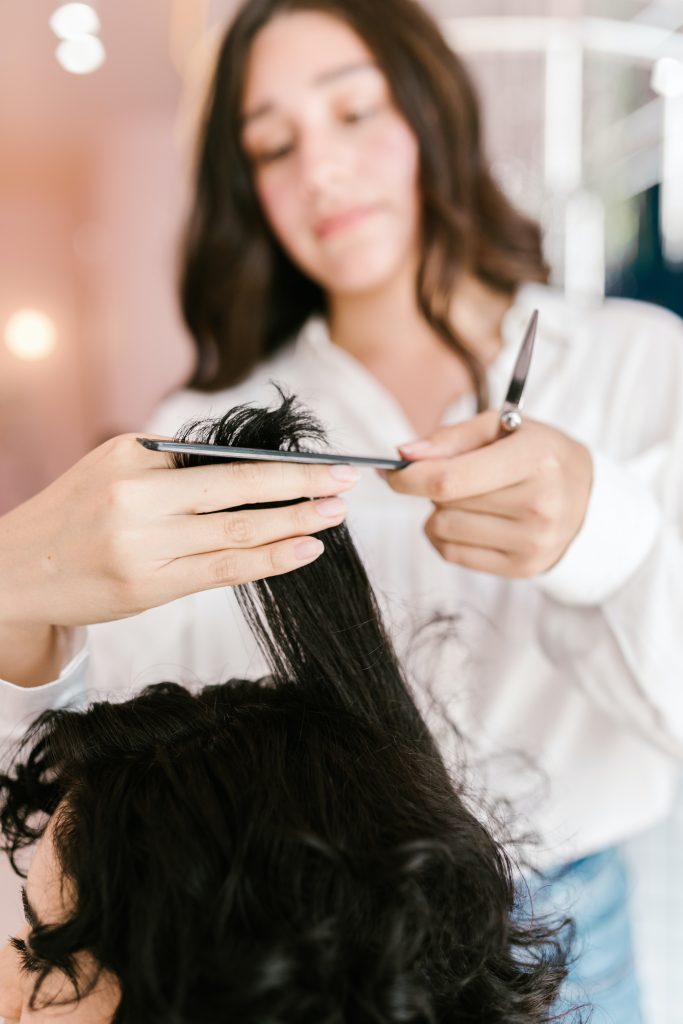coiffeur coupant les cheveux d'une femme