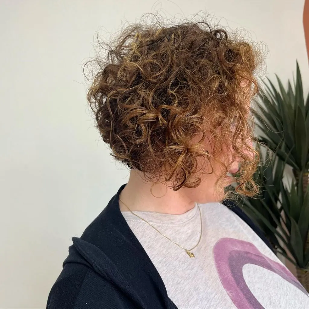 warm blonde balayage on short curly hair