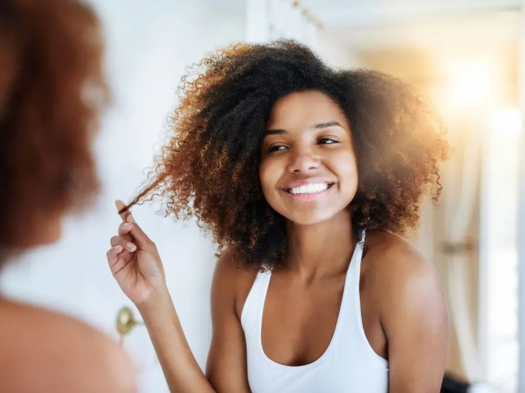 mujer admirando su pelo en el espejo