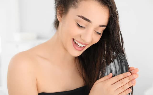 mujer aplicando acondicionador para el cabello