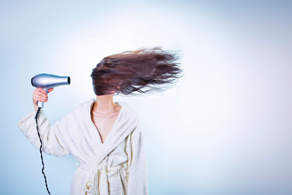femme se séchant les cheveux au sèche-cheveux