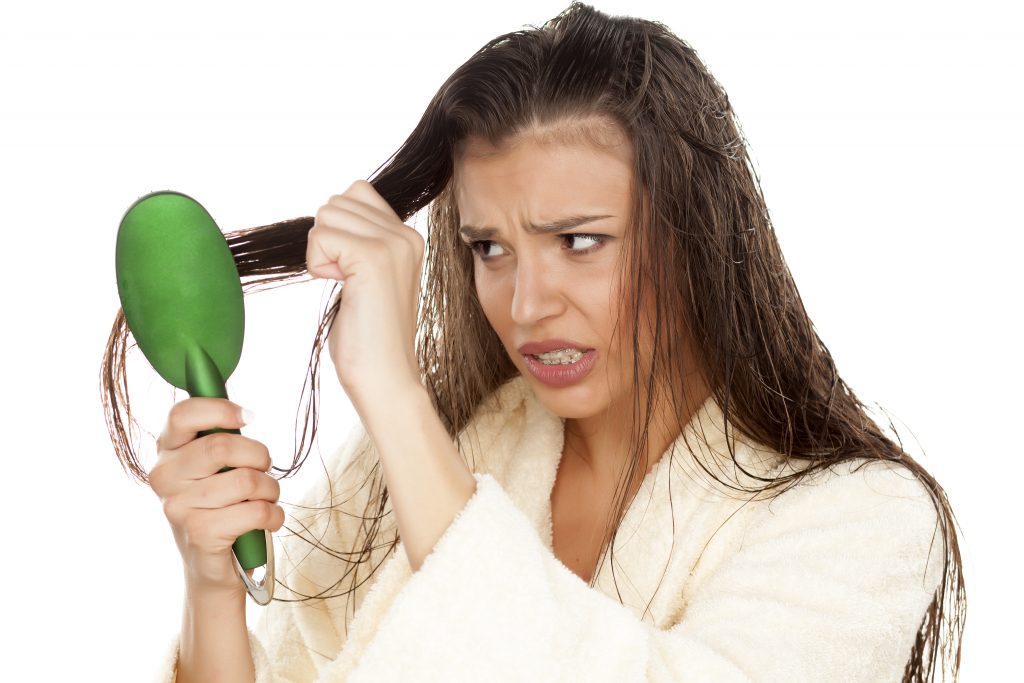 mujer cepillándose el pelo mojado