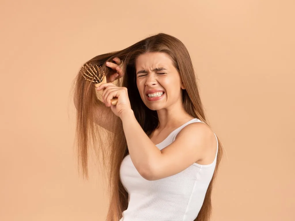 woman combing damaged hair