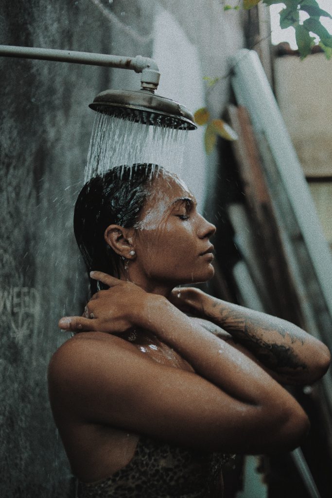 femme se lavant les cheveux sous la douche