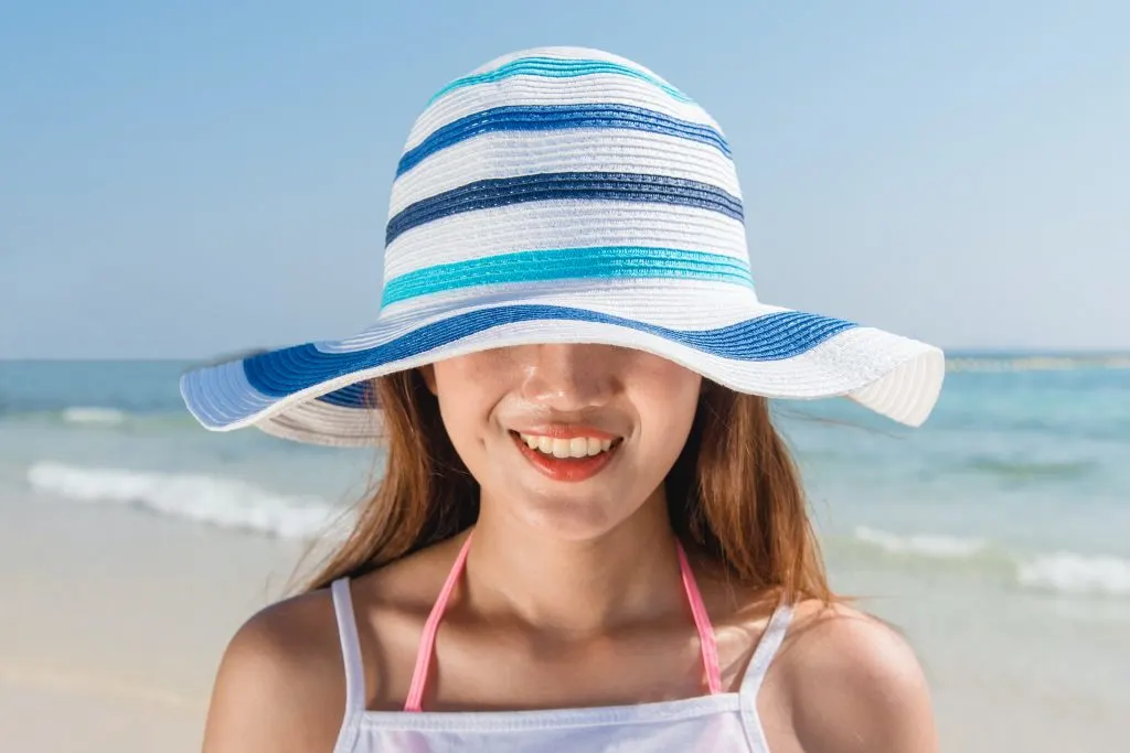woman wearing a hat on the beach