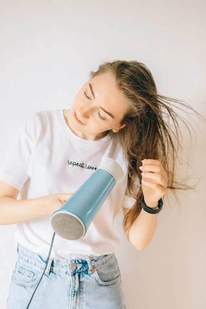 woman drying her hair with a blow dryer