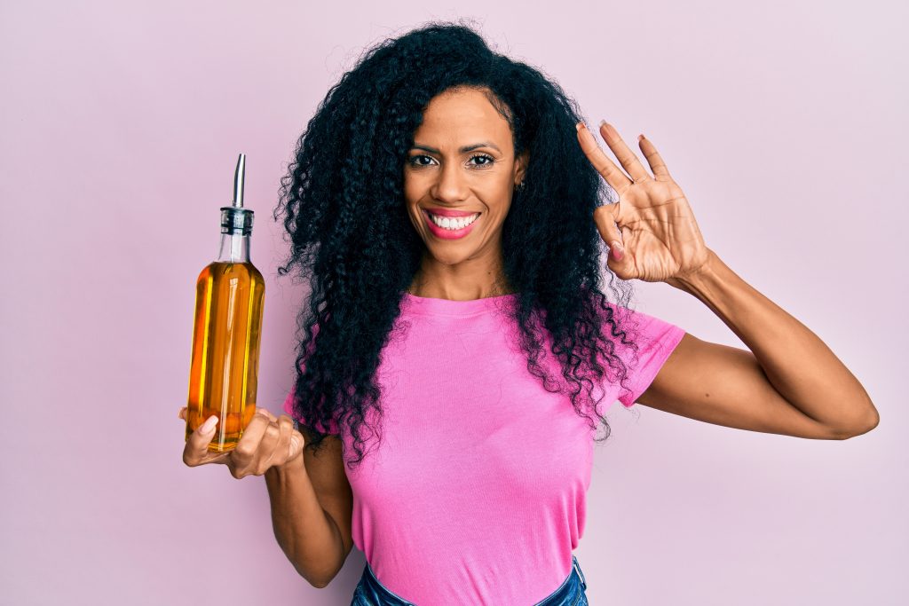 mujer sosteniendo una botella de aceite de oliva