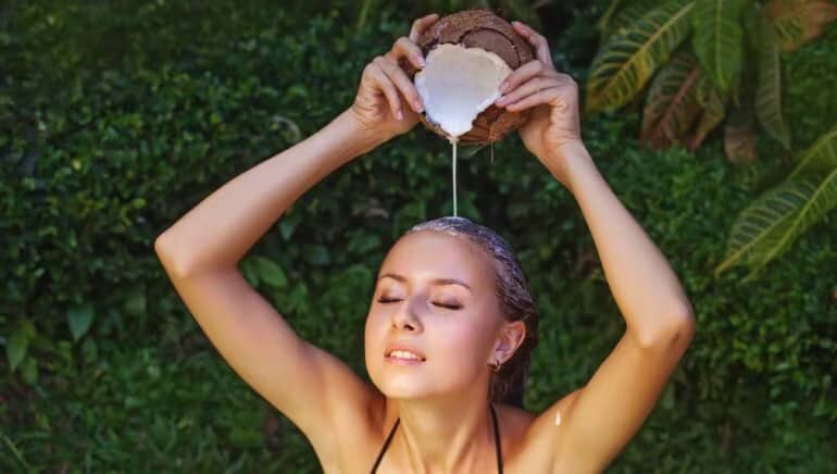 vrouw die kokosmelk op haar haar doet