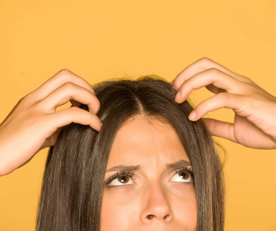 woman rubbing her itchy scalp