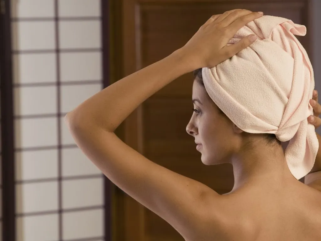 woman wrapping her hair in towel