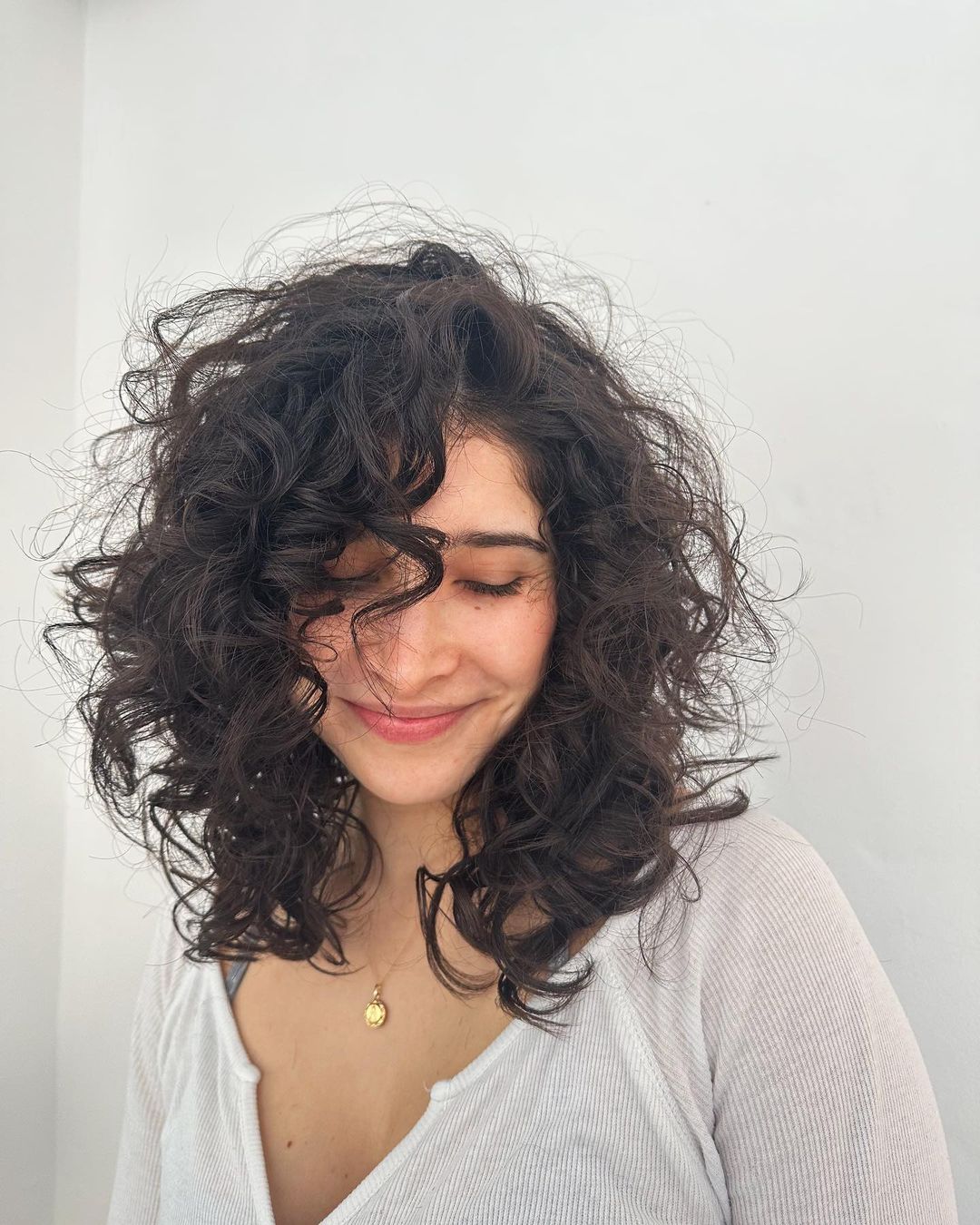 medium curly hair with side-swept bangs