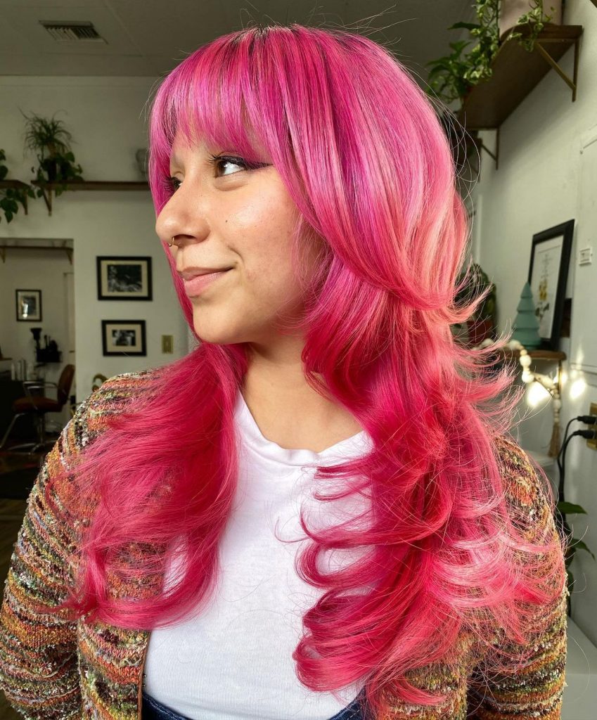 franja a emoldurar o rosto num cabelo comprido em camadas cor-de-rosa
