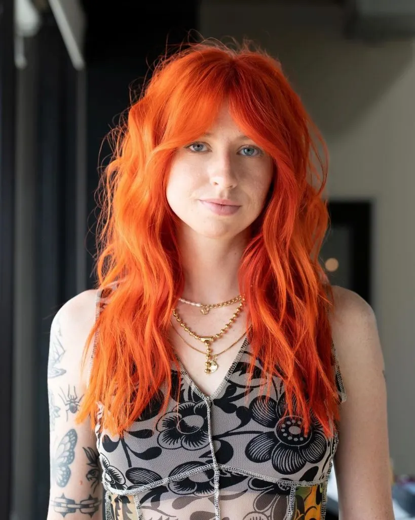 vibrant orange long hairstyle with bangs