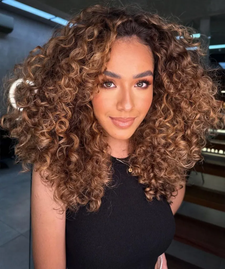 brunette curls with caramel highlights