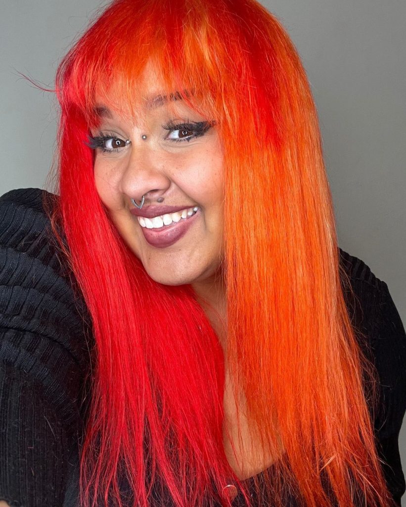 cheveux d'un rouge vif presque orange