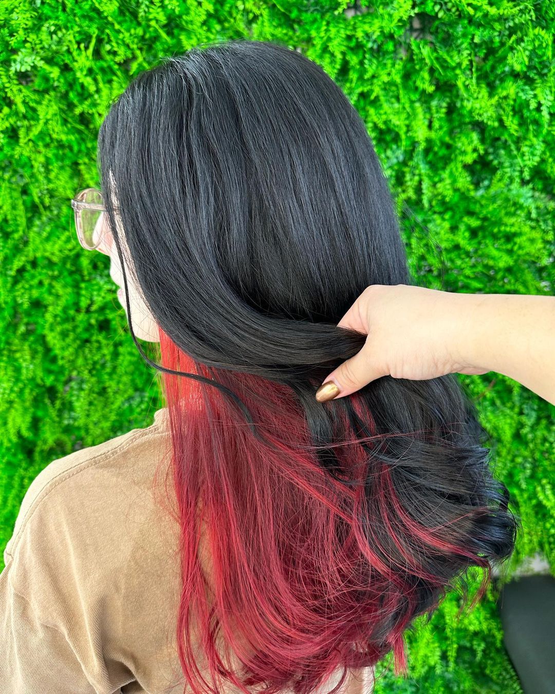 capelli neri con balayage rosso interno