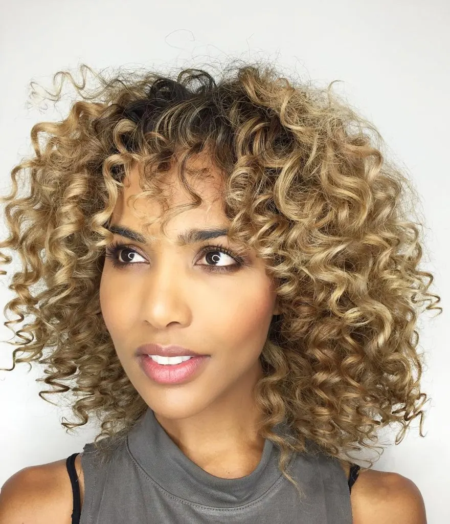blonde highlights on curly hair with bangs