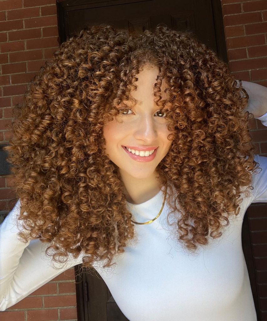curly ginger hair with parted bangs