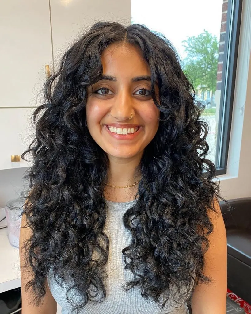 a woman with a face-framing long curly hairstyle
