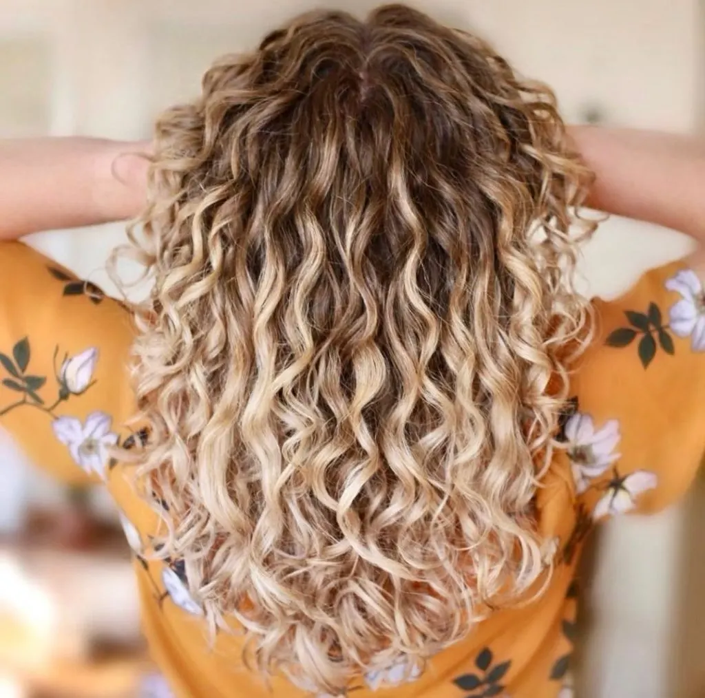 long blonde curls with dark roots hairstyle