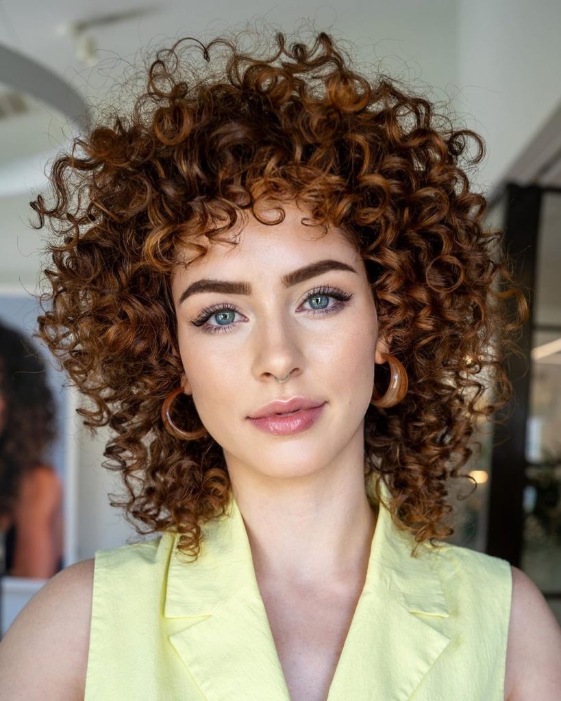 a girl with medium length curly cowboy copper hairstyle