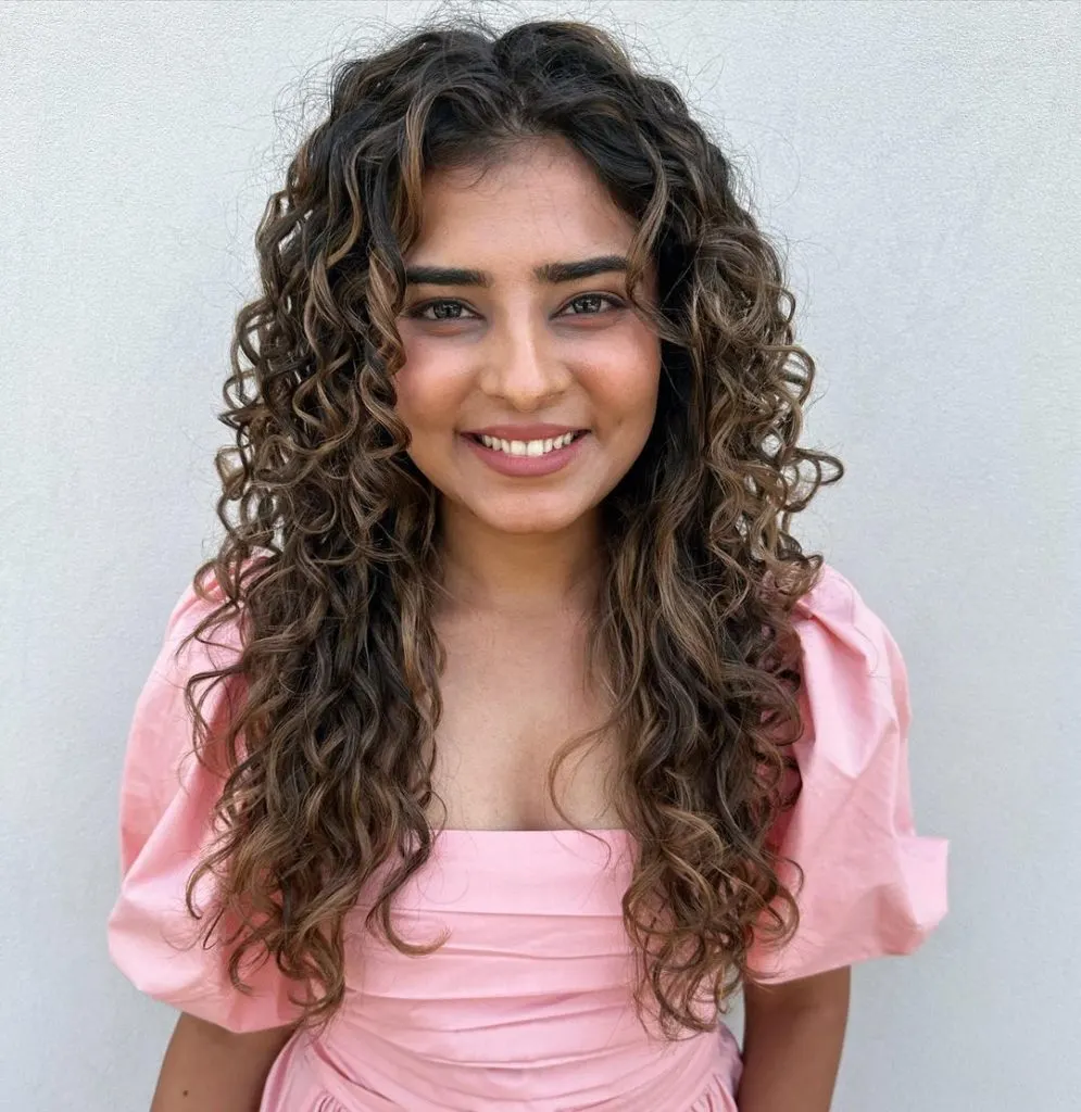 a young girl with subtle balayage curly hairstyle