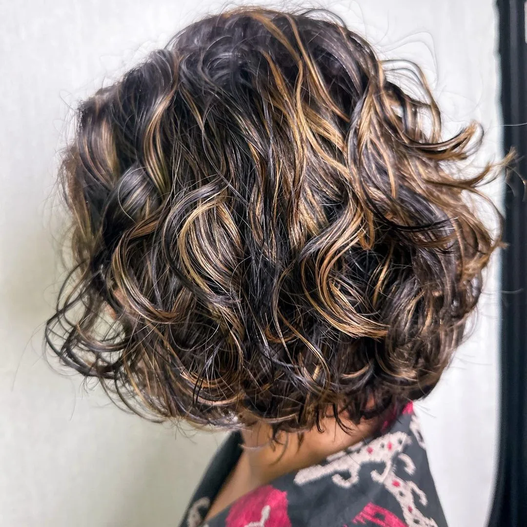 A line curly cut with honey golden highlights