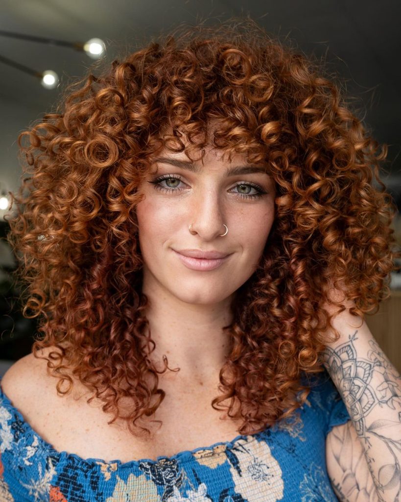 uma mulher com uma cabeleira arredondada em cobre