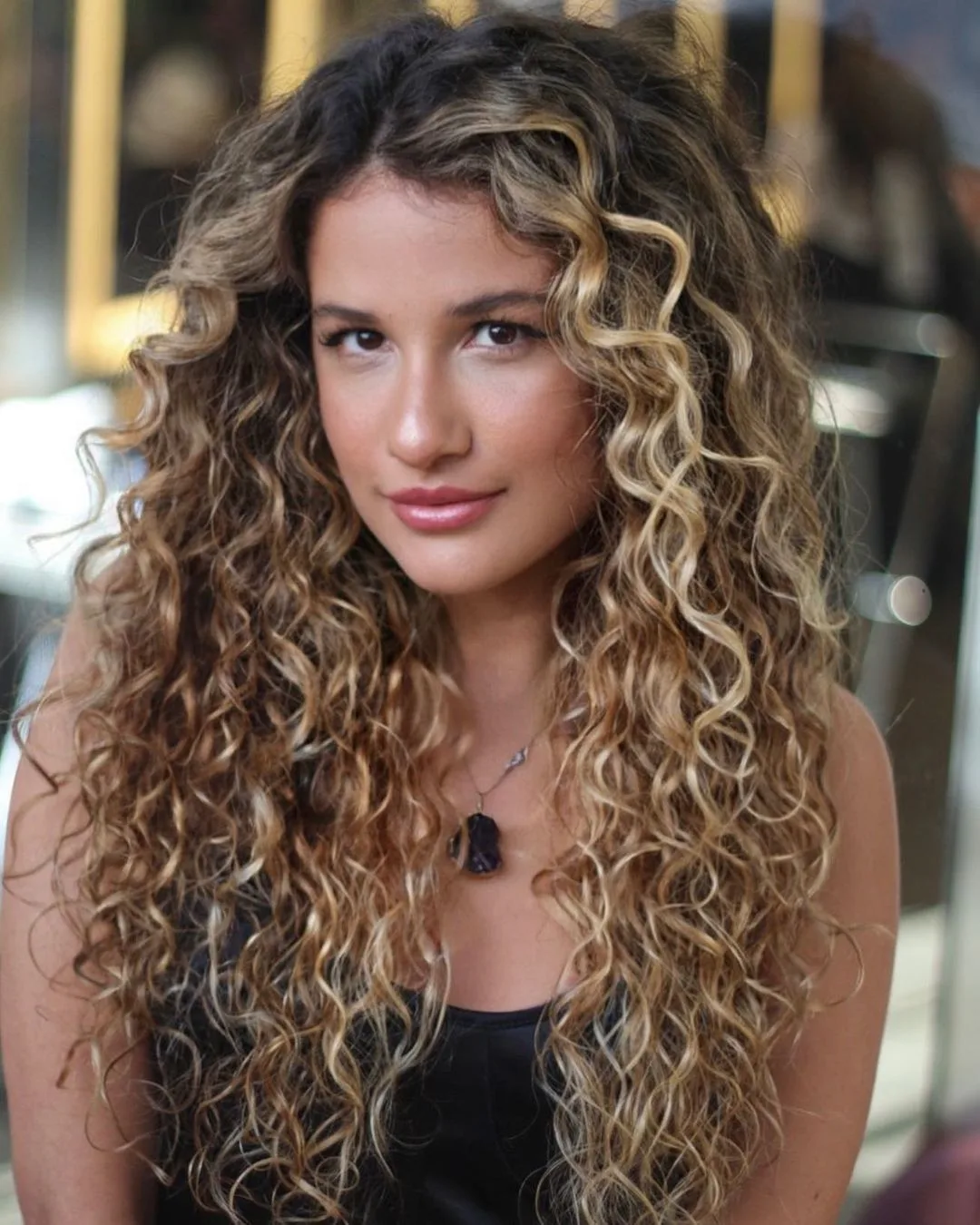 long curly hair with layers and blonde balayage