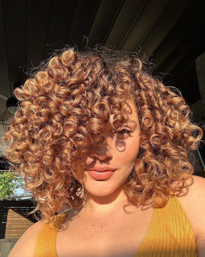 a woman with honey bouncy curls