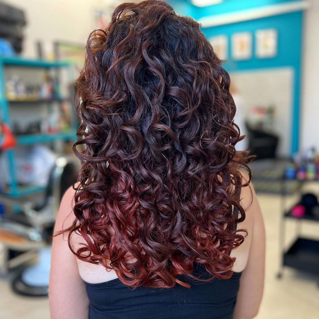 a woman with loose auburn curls 