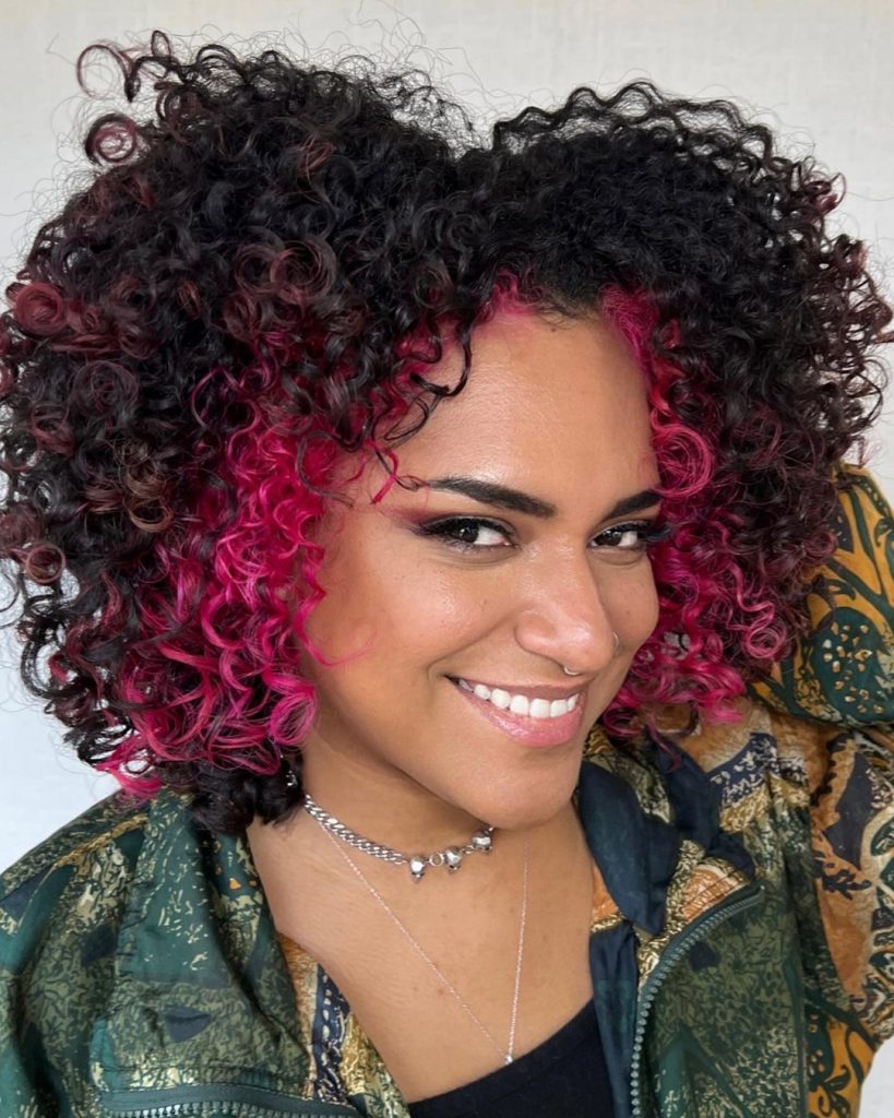 penteado encaracolado baddie com madeixas cor-de-rosa a emoldurar o rosto