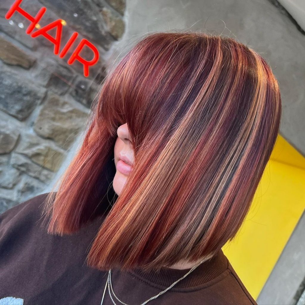 red inverted bob cut with blonde highlights