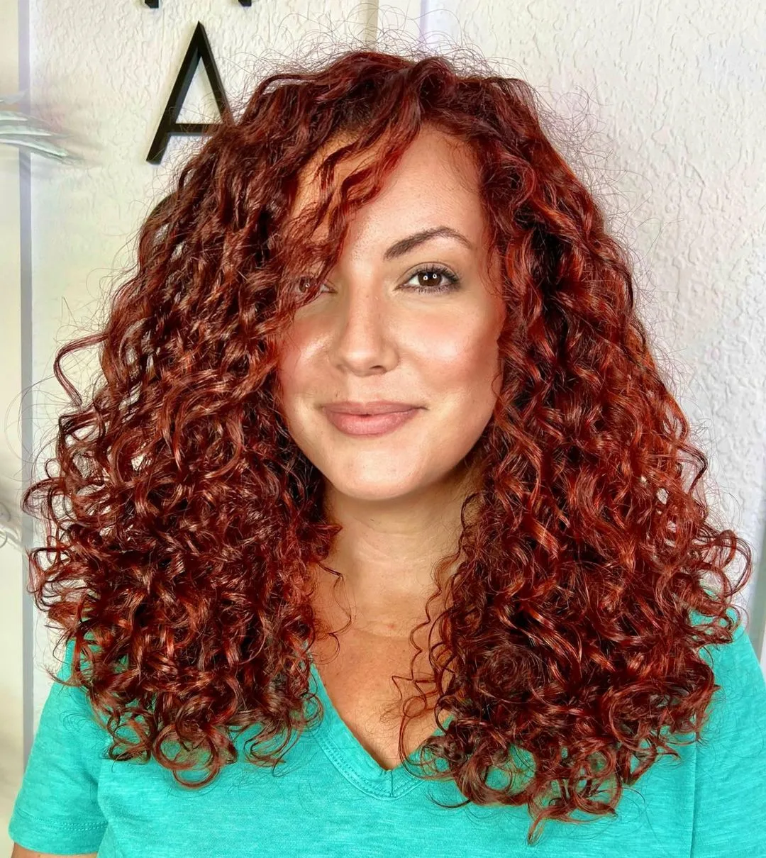 layered curly hair with a deep side part