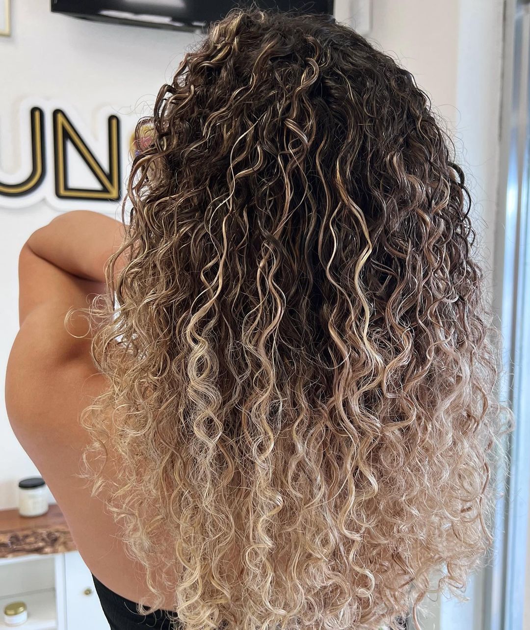 sunkissed blonde balayage on curly hair
