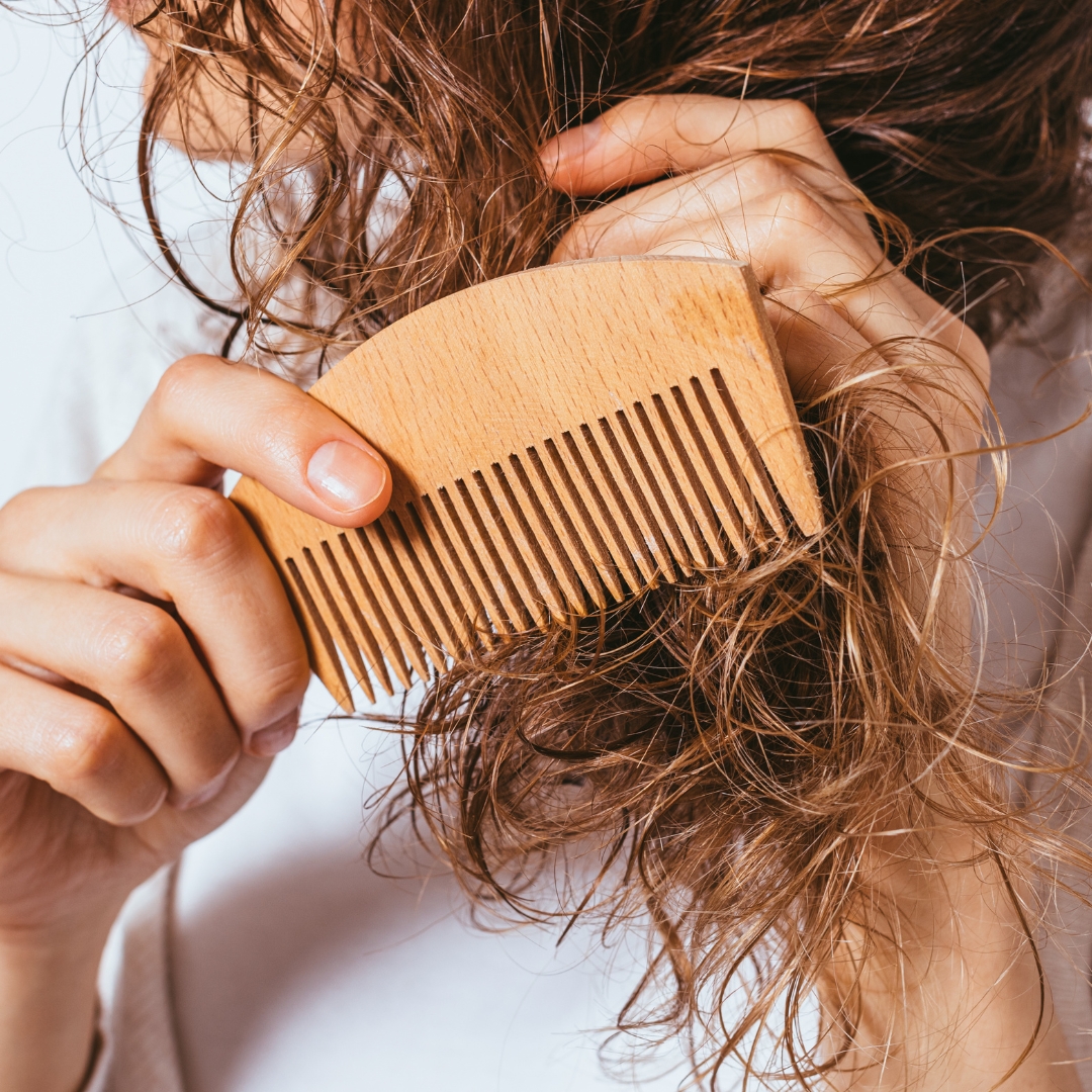 a woman combing her hair from the bottom up
