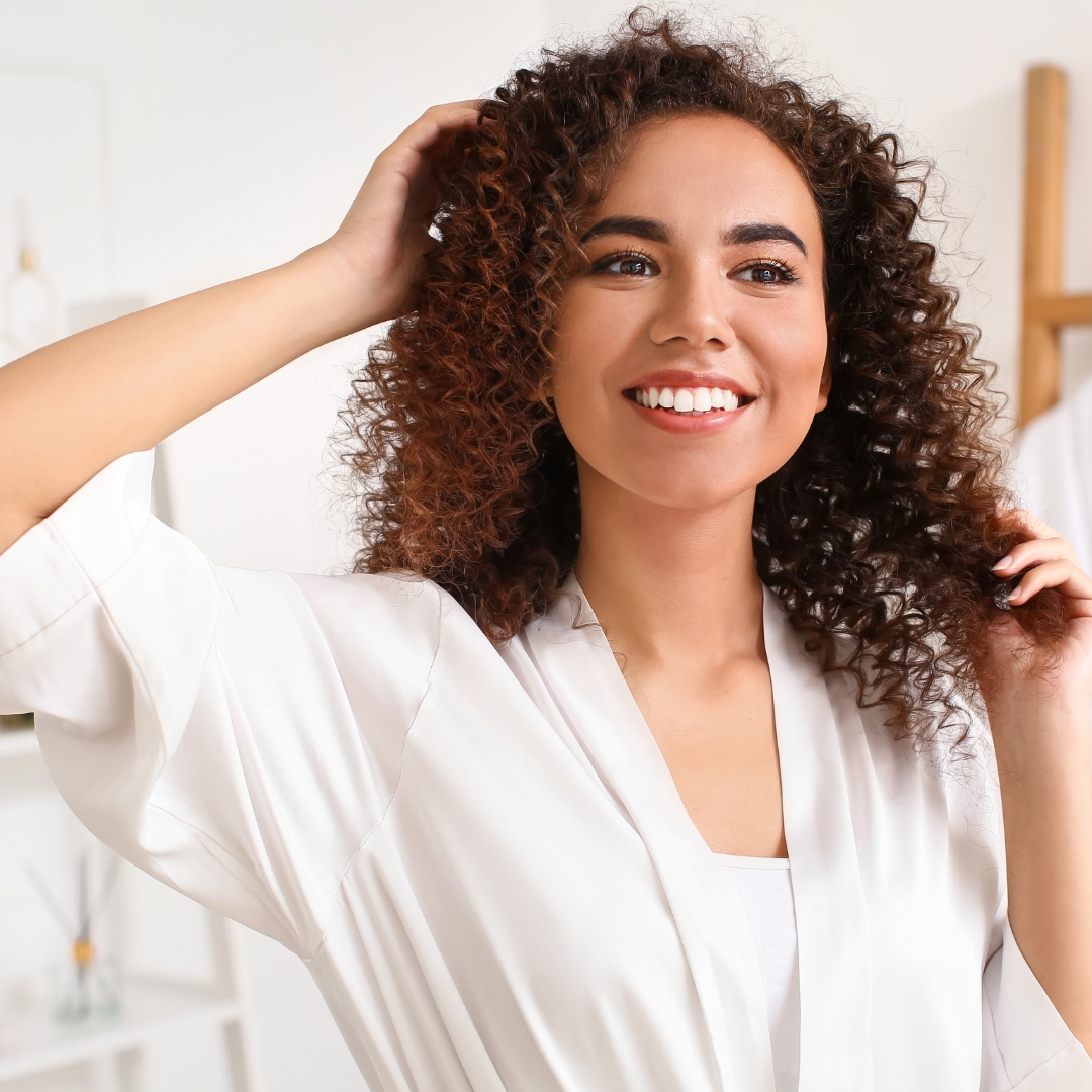 a woman taking care of her curly hair by following curly girl method