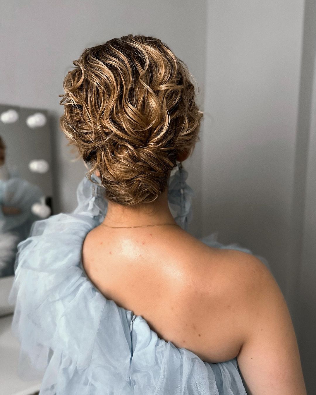 low curly bun with blonde highlights