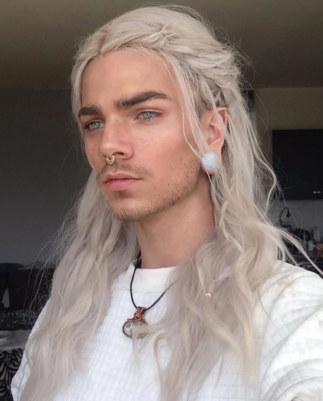 man with long blonde legolas kind of hair and piercing
