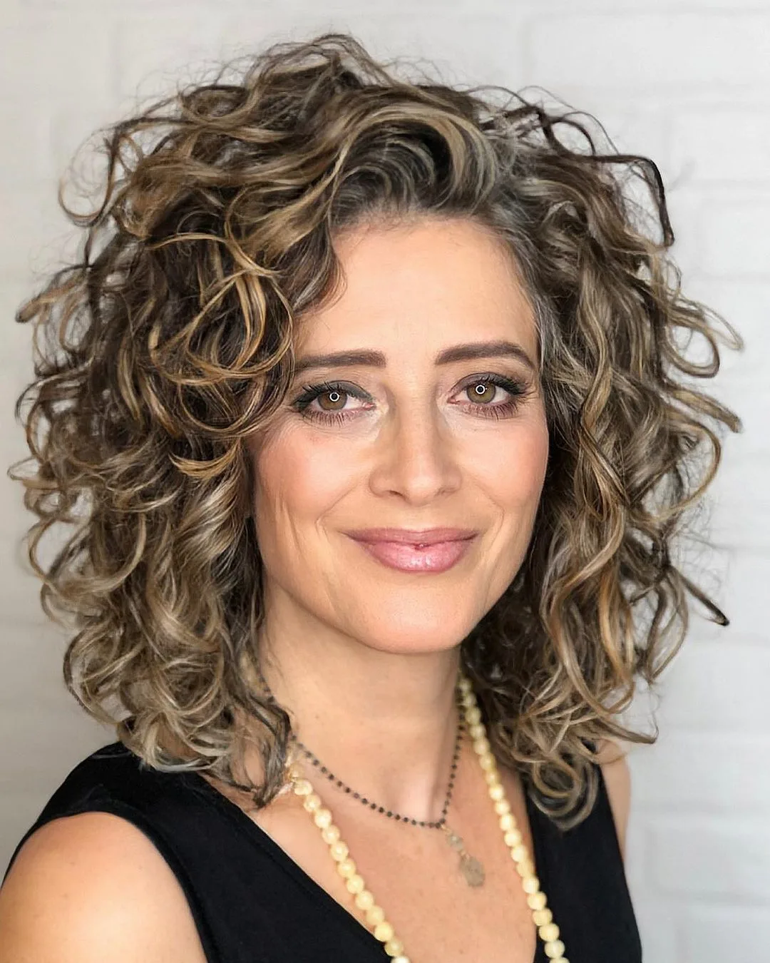 medium curly hairstyle with a deep side part