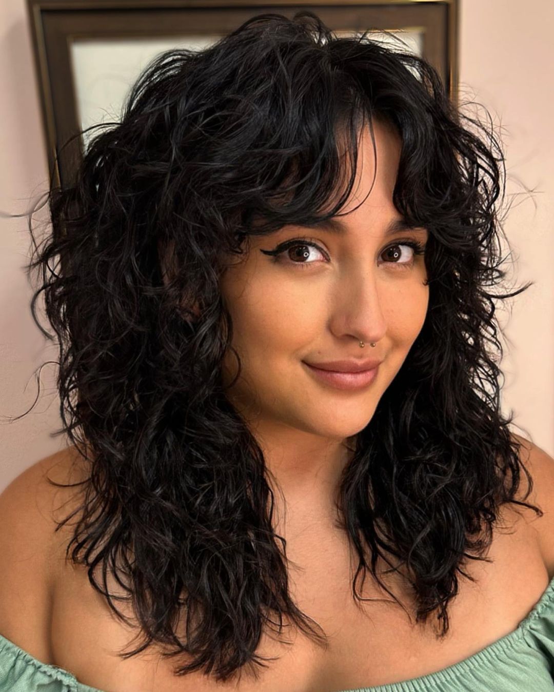 Medium-length curly hair with curtain bangs
