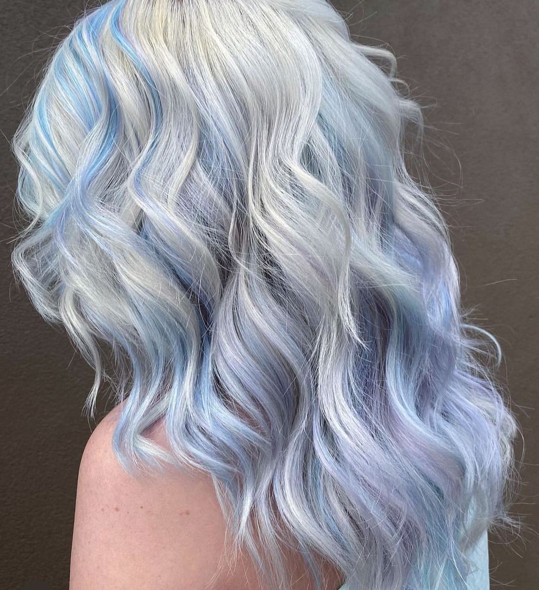 blond platine avec des reflets bleu pastel et violet pastel cheveux ondulés