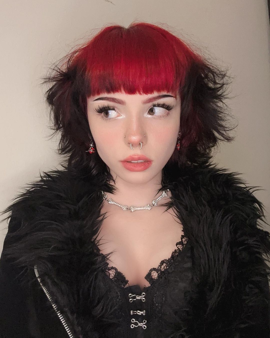 choppy short black cut with red roots and bangs