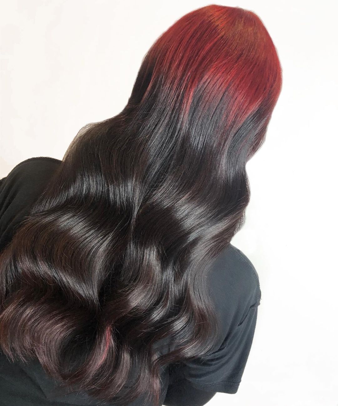 racines rouge foncé sur cheveux noirs