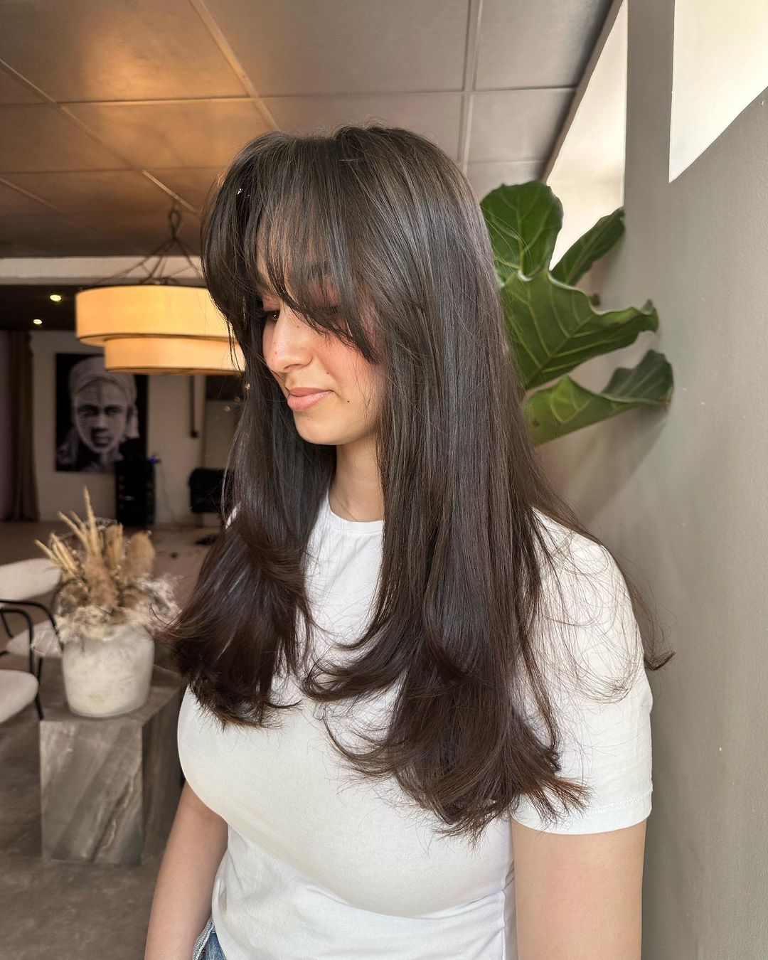 brunette with long layered hair and wispy curtain bangs